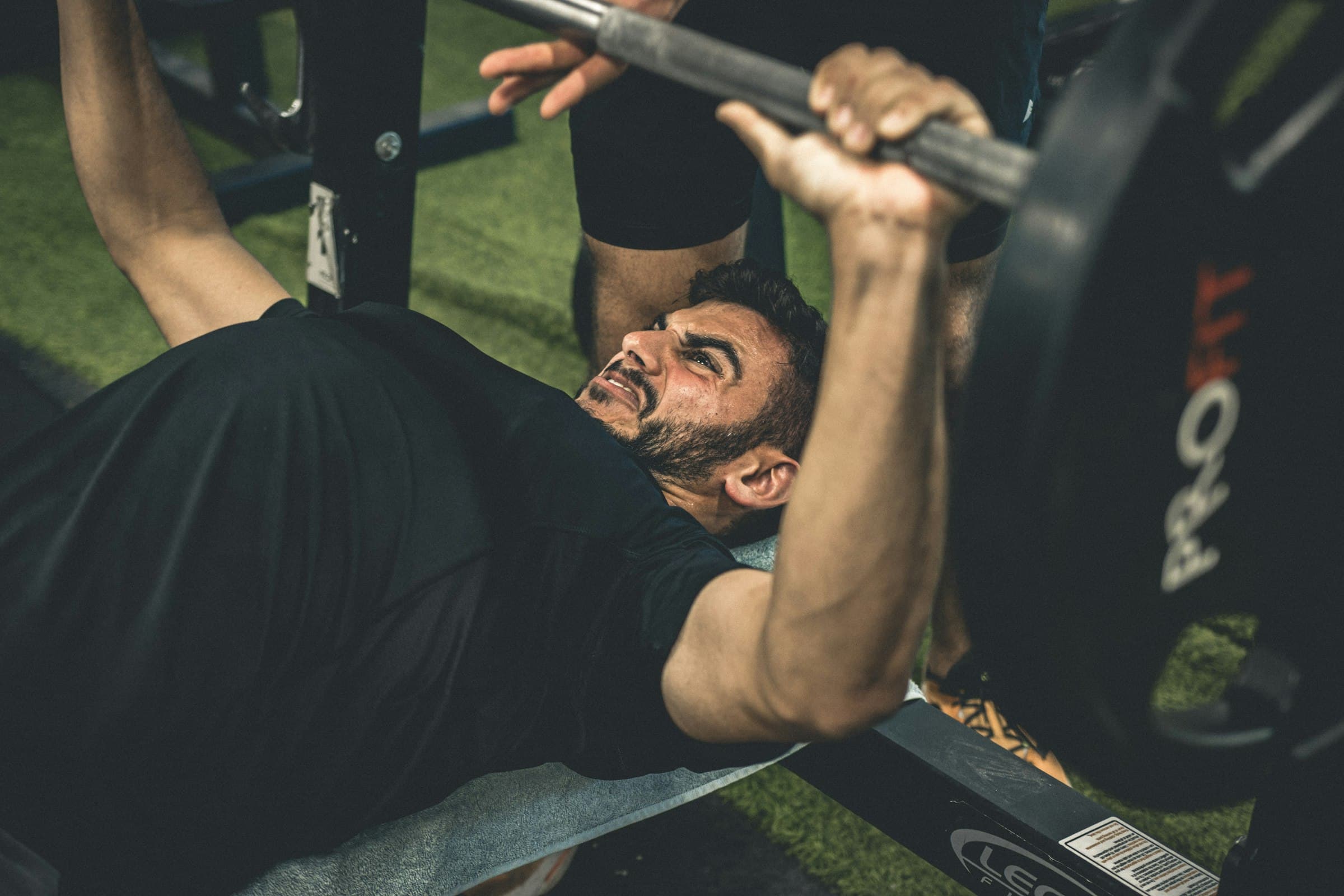 A man pressing a barbell on a flat bench